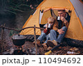 Man and boy tourists autumn time leisure, vacation hiking or traveling touristic activity. Family camping, father and little son relax in forest camp. 110494692