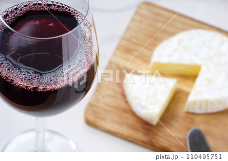 ワイングラスに注いだ赤ワインとカマンベールチーズ ワイングラスに注いだ赤ワインとカマンベールチーズ 110495751