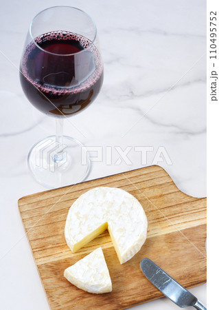 ワイングラスに注いだ赤ワインとカマンベールチーズ 110495752