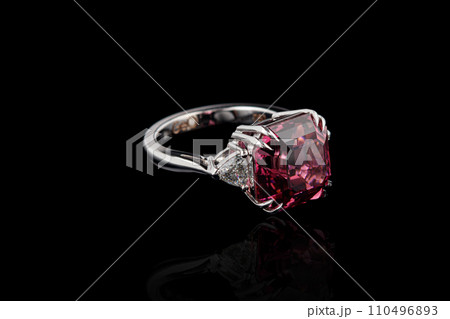 beautiful gold ring with tourmaline and diamond gemstones on a black background 110496893