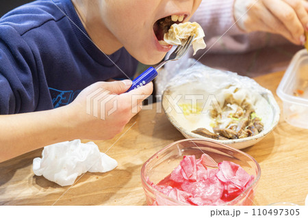 家族と食事をする7歳の男の子 家族と食事をする7歳の男の子 110497305