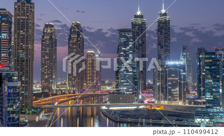 Cityscape with skyscrapers of Dubai Business Bay and water canal aerial day to night timelapse. 110499412