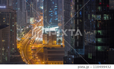 Aerial view from above to a busy road junction in Dubai all night timelapse. Aerial view from above to a busy road junction in Dubai all night timelapse. 110499432