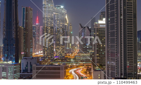 Many towers and skyscrapers with traffic on streets in Dubai Downtown and financial district day to night timelapse. 110499463