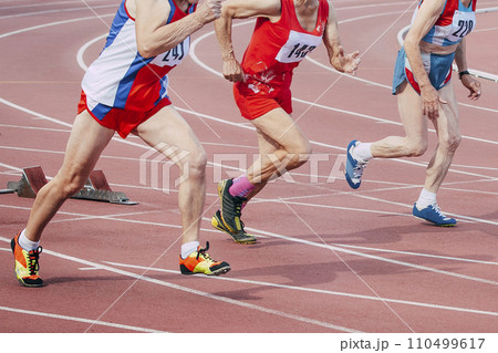 seniors woman runner running start 100 metres race in masters athletics 110499617