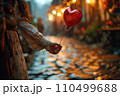 Floating on Love's Breeze, a Red Balloon Held Aloft, a Valentine's Day Sentiment in Hand 110499688