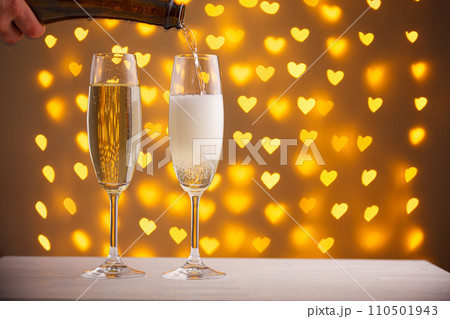 beautiful glasses of champagne on a blurred background of hearts 110501943