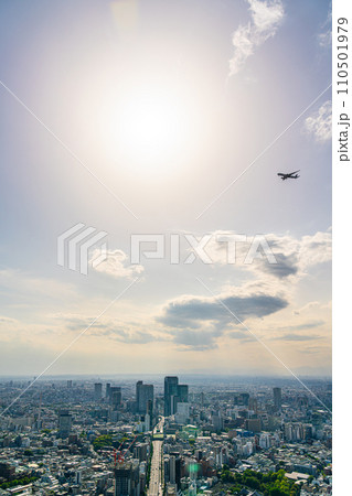 【東京都】渋谷の街並みの上空を飛ぶ飛行機 110501979