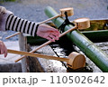手水舎で手を洗う 110502642