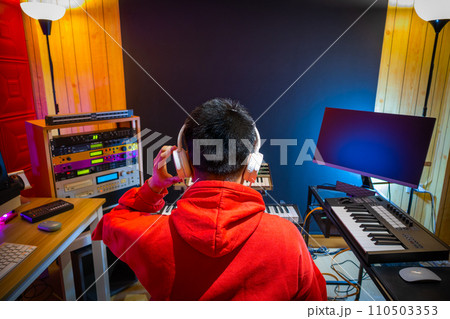 back of asian male music producer, composer, musician arranging a hit song in home studio. music production concept 110503353