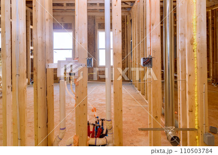 Wooden framing of new construction home with beams is adhered to framework 110503784