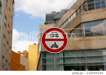 Road sign showing no entry for cars or motorcycles. Traffic sign has circle shape and is red and white with pictograms of automobile and motorbike. 110504165