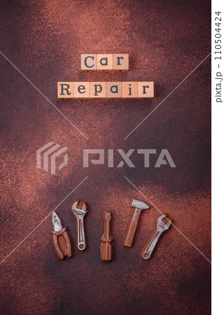 Tools and inscriptions symbolizing repairs or a garage and its attributes on a plain background 110504424