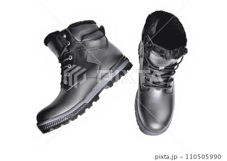 Winter black leather boots on a white background, hiking shoes, practical off-road shoes, close-up Winter black leather boots on a white background, hiking shoes, practical off-road shoes, close-up 110505990