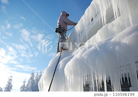 Removing dangerous icicles from the roof of a family house, danger of falling 110506199