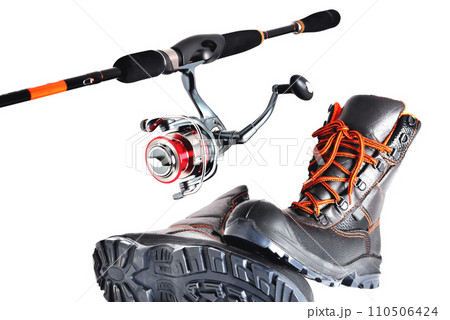 Spinning with a reel and off-road shoes with orange laces on a white background, isolate Spinning with a reel and off-road shoes with orange laces on a white background, isolate 110506424