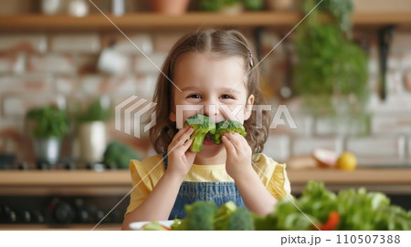 happy child eats broccoli in modern kitchen. portrait 110507388