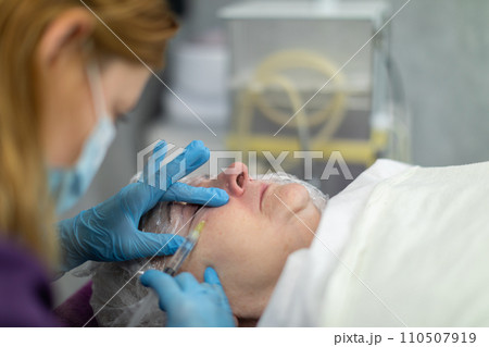 The woman contorts her face in a grimace of pain. 110507919