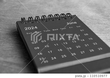 Black and white June 2024 desk calendar on wooden desk. New month concept Black and white June 2024 desk calendar on wooden desk. New month concept 110510977