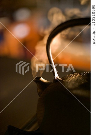 朝焼けの中、鉄瓶でお湯を沸かしているところ 110510999