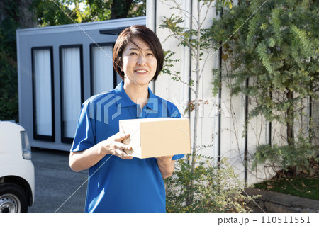 荷物を運ぶ宅配便の女性配達員 110511551
