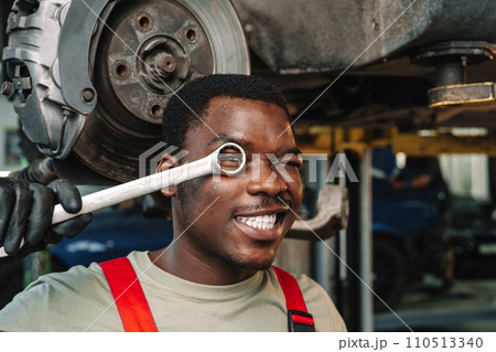 African man mechanic in uniform at the car repair station, portrait African man mechanic in uniform at the car repair station, portrait 110513340