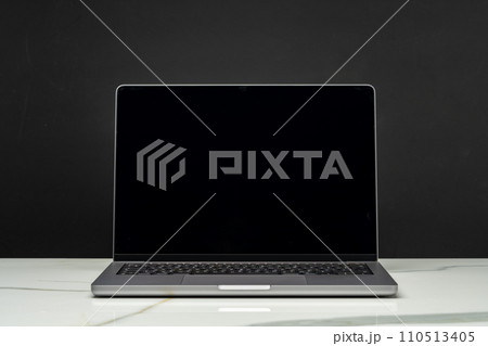 Open laptop with black screen against black background 110513405