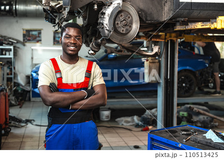 Portrait of young african man car service worker wearing uniform standing in garage 110513425