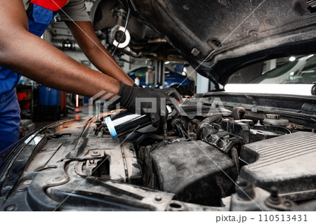 Close up of hands of auto mechanic working in a garage 110513431