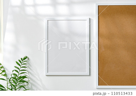 Cork board and blank frame hanging on the wall 110513433