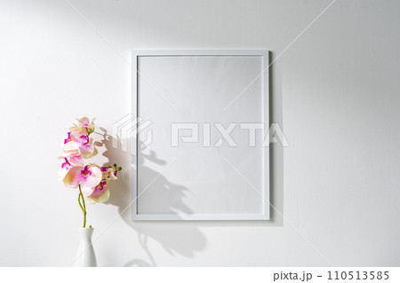 White wooden frame on white wall above the table White wooden frame on white wall above the table 110513585