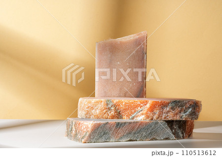 Pieces of granite stones against beige background with shadows Pieces of granite stones against beige background with shadows 110513612
