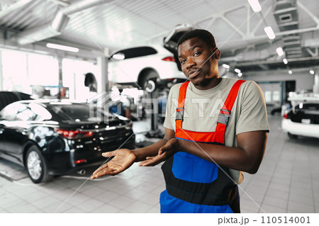African man mechanic in uniform at the car repair station, portrait 110514001