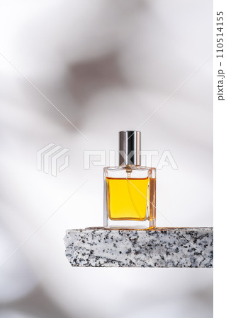 Perfume bottle on granite stones against white background with shadows Perfume bottle on granite stones against white background with shadows 110514155