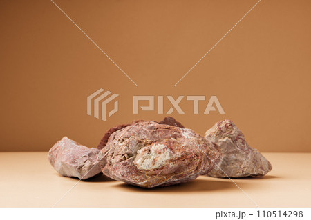 Piece of granite stone against beige background with shadows 110514298