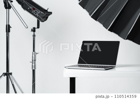 Laptop with black screen and photography equipment in photostudio Laptop with black screen and photography equipment in photostudio 110514359