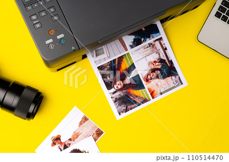 Printer printing colorful photos of people close up, yellow background Printer printing colorful photos of people close up, yellow background 110514470