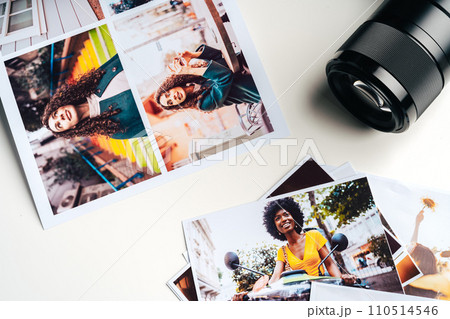 Camera and colorful printed photos of women on desk close up Camera and colorful printed photos of women on desk close up 110514546