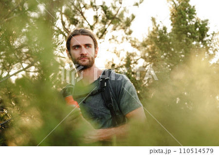 Hiker man with backpack holding thermos in his hand 110514579