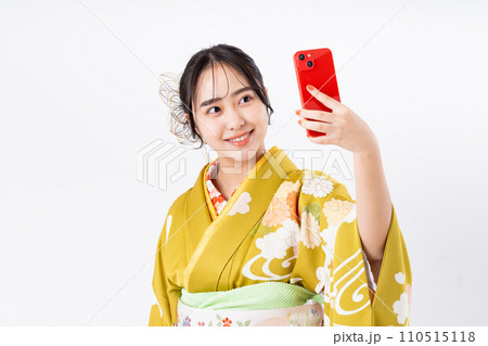 振り袖でスマホを使う若い女性 110515118