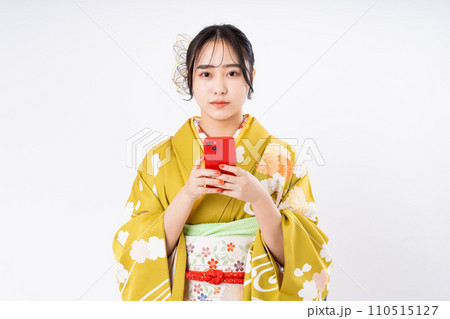 振り袖でスマホを使う若い女性 110515127
