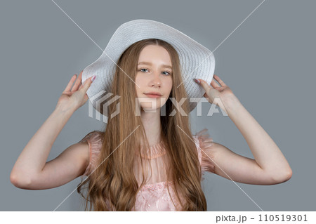 Portrait of a romantic girl with long blond hair in a wide-brimmed hat. Portrait of a romantic girl with long blond hair in a wide-brimmed hat. 110519301