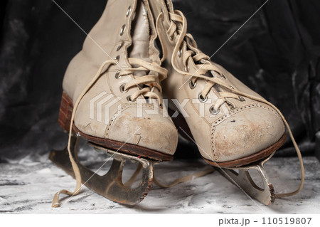 Vintage old skates on a snowy background. Vintage old skates on a snowy background. 110519807
