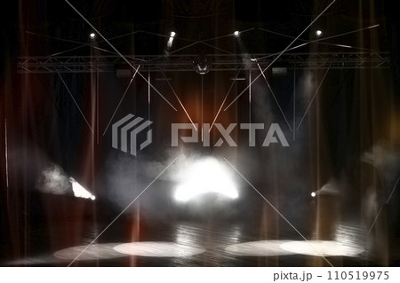Stage lighting with laser illumination and puffs of smoke. Dark stage background. Stage lighting with laser illumination and puffs of smoke. Dark stage background. 110519975