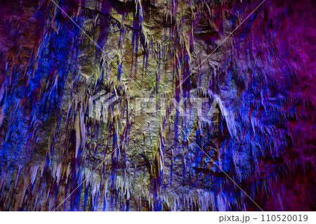 Karst cave, amazing view of stalactites and stalagnites in colorful bright light, beautiful natural landmark in touristic place. 110520019
