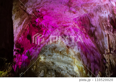 Karst cave, amazing view of stalactites and stalagnites in colorful bright light, beautiful natural landmark in touristic place. 110520020