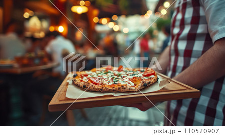 Cute old cafe on a neighborhood street, waiter carries pizza on a wooden tray to customers, selective focus on pizza, lunch concept with copy space 110520907