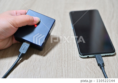 モバイルバッテリーでスマホを充電する人 スマホ充電警告 モバイルバッテリーでスマホを充電する人 スマホ充電警告 110522144