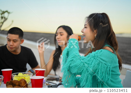 Happy young people celebrating together having dinner party on rooftop in the evening 110523451