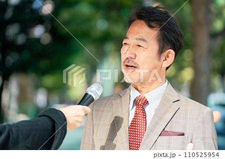 街頭インタビューに答える男性 110525954